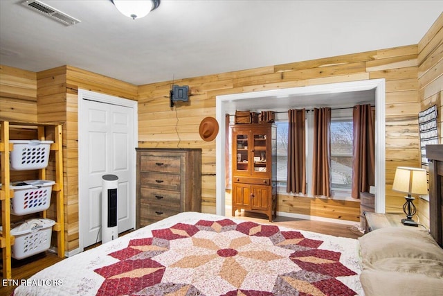 bedroom featuring wood walls and wood-type flooring