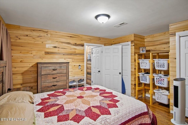 bedroom featuring wood walls and hardwood / wood-style flooring