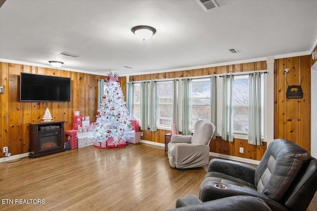 living room featuring a fireplace, hardwood / wood-style floors, and wood walls