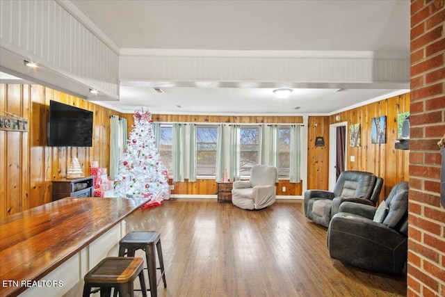 living room with ornamental molding, hardwood / wood-style flooring, and wooden walls