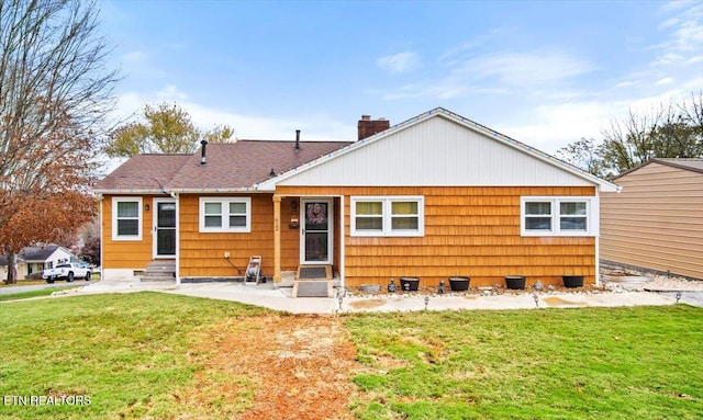 rear view of property featuring a yard