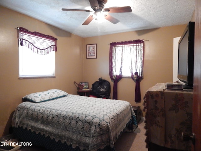 bedroom featuring a textured ceiling, carpet floors, and ceiling fan