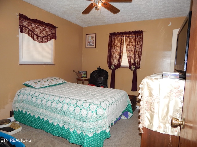 bedroom featuring ceiling fan, carpet floors, and a textured ceiling