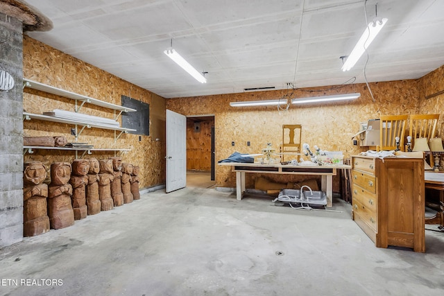 miscellaneous room featuring concrete flooring and a workshop area