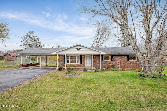 ranch-style home featuring a front lawn and a carport