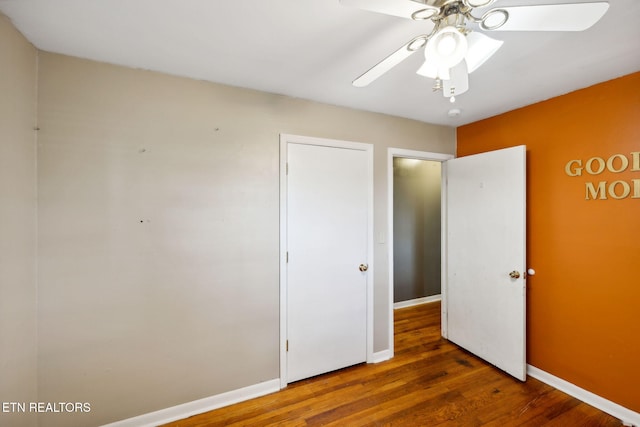 unfurnished bedroom featuring ceiling fan and dark hardwood / wood-style floors