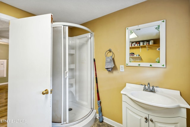 bathroom featuring a textured ceiling, vanity, and walk in shower