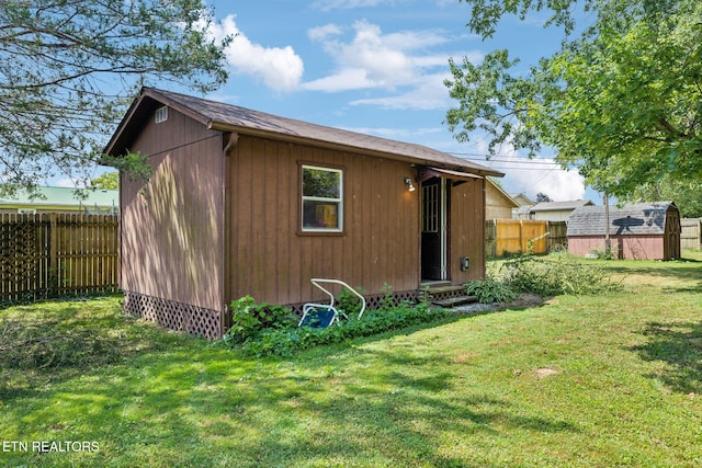 rear view of house with a yard and a shed