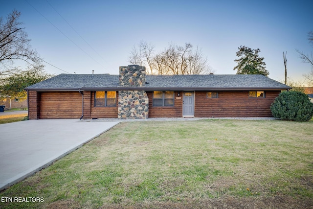 view of front of home with a shingled roof, a chimney, and a front yard