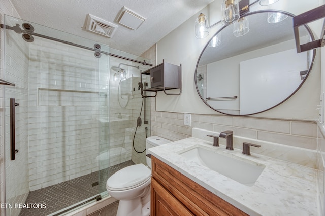 bathroom with decorative backsplash, toilet, a shower with door, and vanity