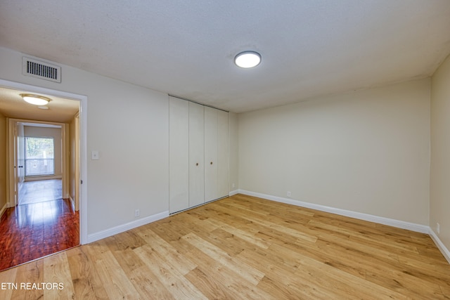 interior space with a closet, light hardwood / wood-style floors, and a textured ceiling