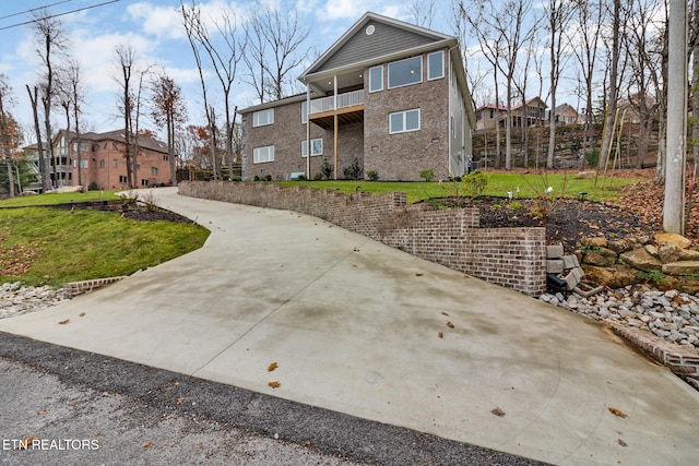 exterior space featuring a balcony and a front lawn