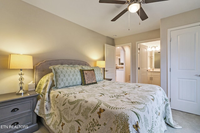 carpeted bedroom with ensuite bathroom and ceiling fan