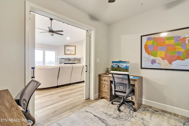 office space with light wood-type flooring, vaulted ceiling, and ceiling fan