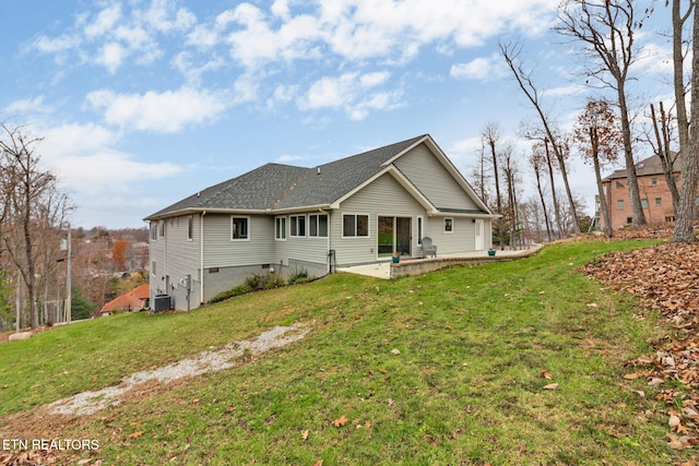 rear view of house with a lawn, a patio area, and central AC