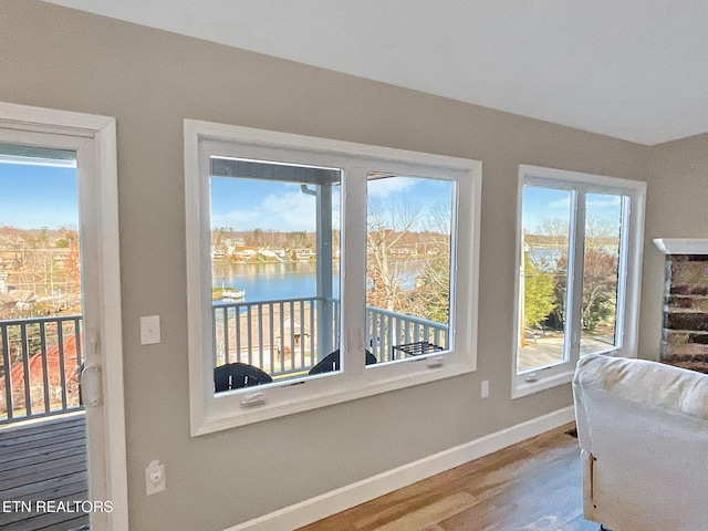 doorway to outside with hardwood / wood-style floors and a water view