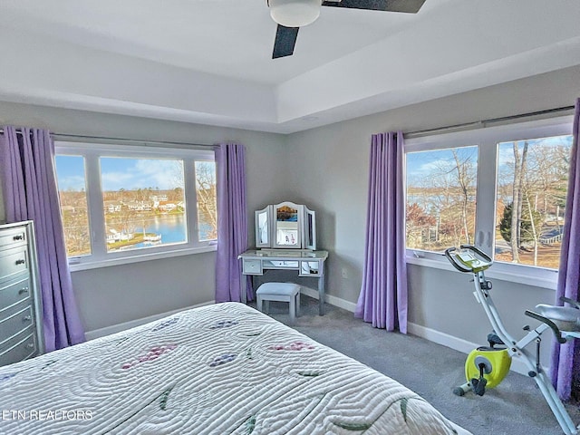 carpeted bedroom featuring a water view and ceiling fan