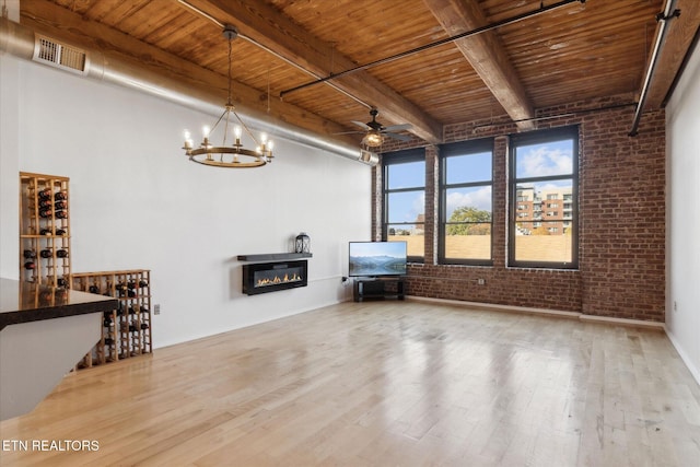 unfurnished living room featuring light wood-type flooring, brick wall, and wooden ceiling