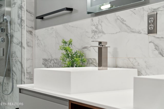 bathroom with a tile shower and sink