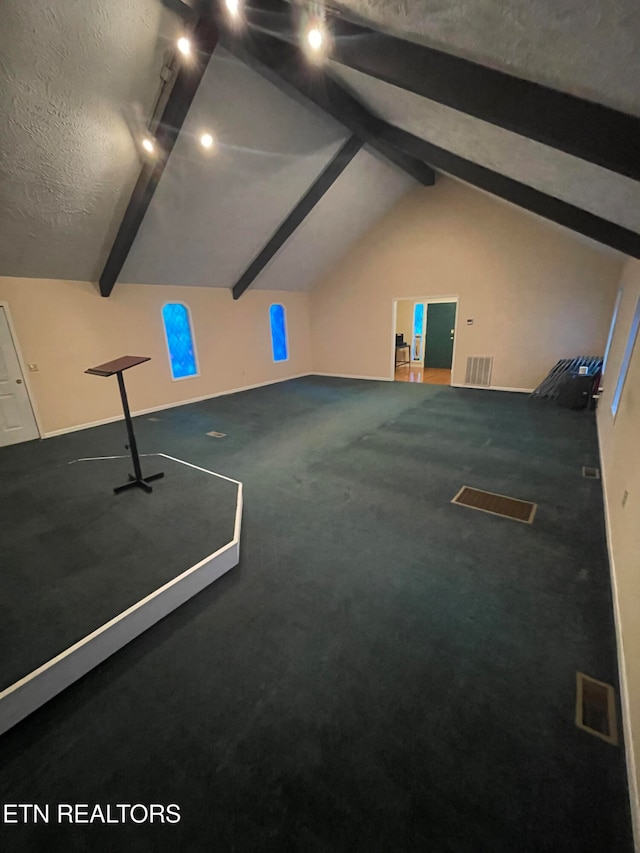 interior space featuring vaulted ceiling with beams, carpet floors, and a textured ceiling