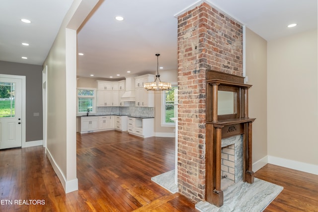 interior space featuring pendant lighting, a healthy amount of sunlight, tasteful backsplash, and white cabinets