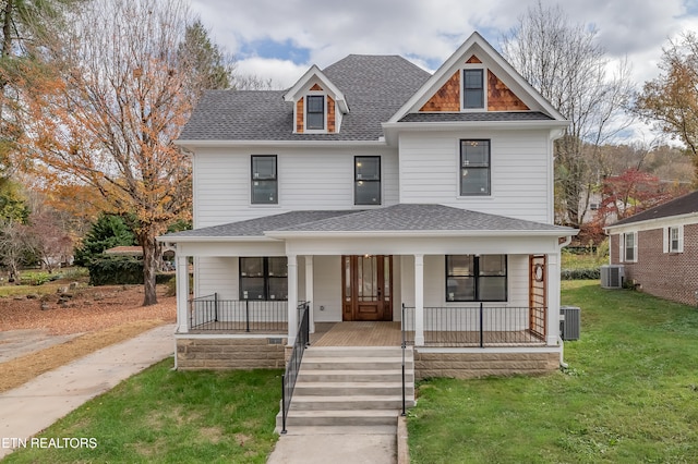 view of front of house featuring central AC, covered porch, and a front yard