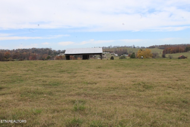 view of yard featuring a rural view and an outbuilding