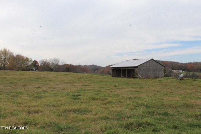 view of yard with an outbuilding and a rural view