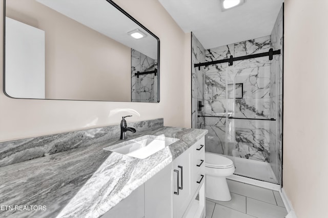 bathroom with tile patterned floors, vanity, toilet, and walk in shower