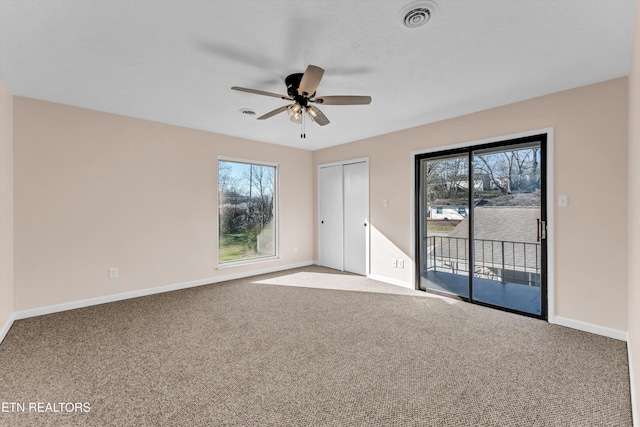 carpeted empty room featuring ceiling fan