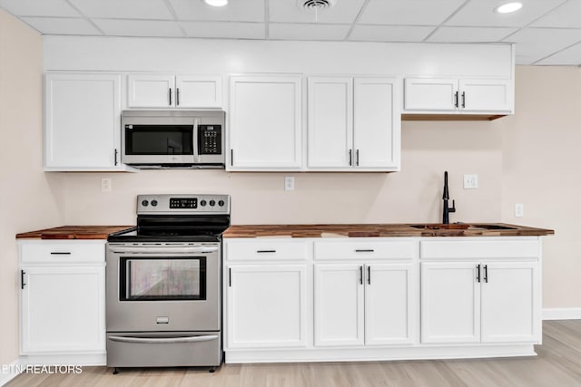 kitchen with sink, a drop ceiling, stainless steel appliances, and wood counters