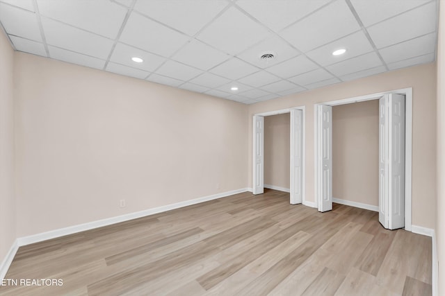 unfurnished bedroom featuring light hardwood / wood-style floors and a drop ceiling