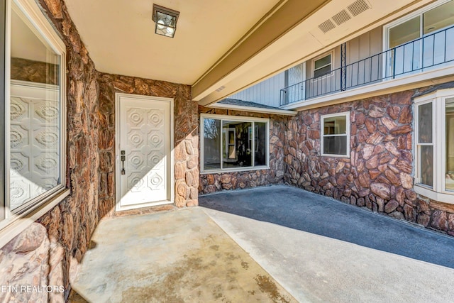 property entrance featuring a balcony and a patio