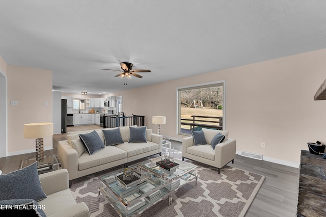 living room with ceiling fan and wood-type flooring