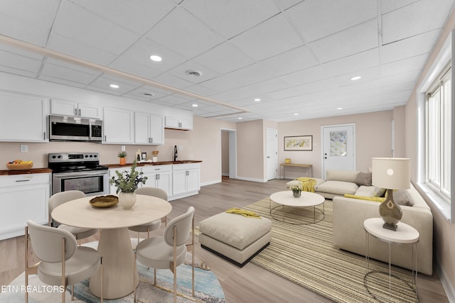 interior space featuring white cabinets, light hardwood / wood-style floors, and appliances with stainless steel finishes