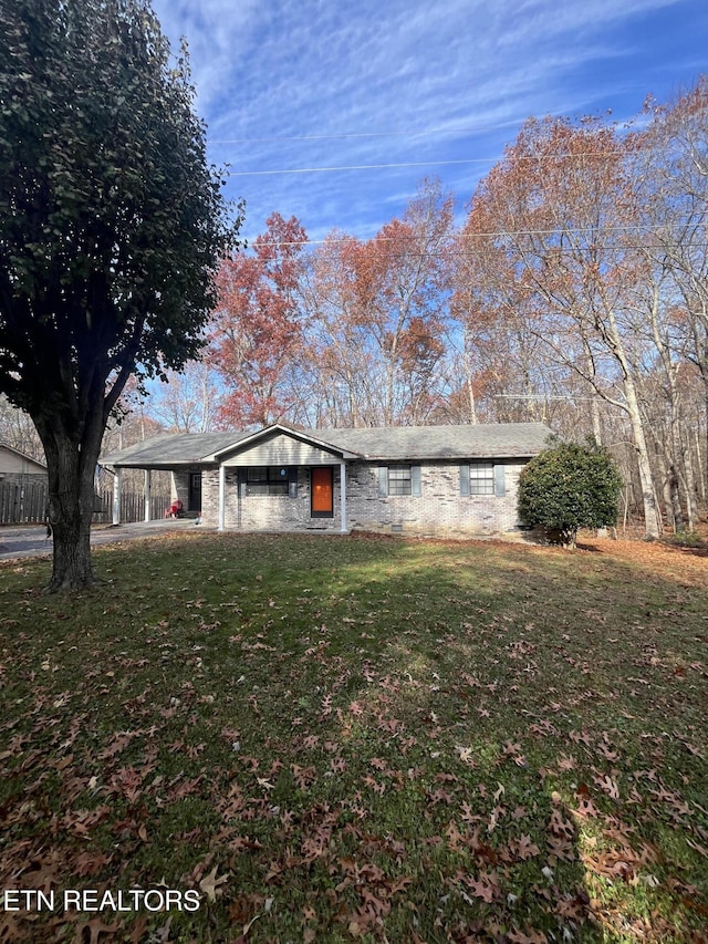 ranch-style home featuring a front lawn and a carport