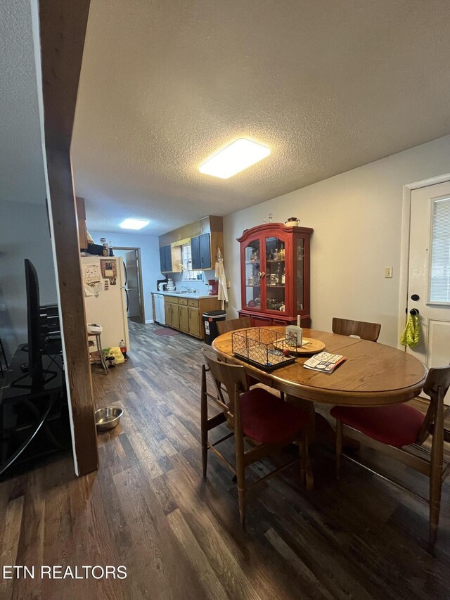 dining space with a textured ceiling and dark hardwood / wood-style floors