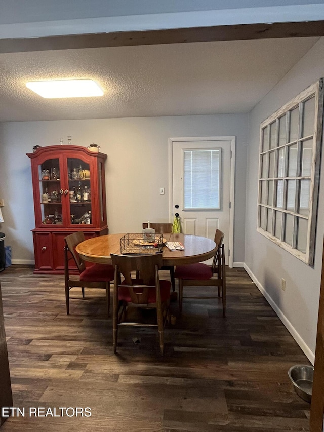 dining room with a textured ceiling and dark hardwood / wood-style floors