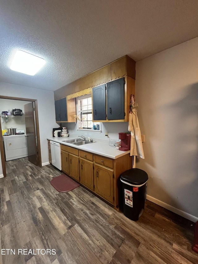 kitchen featuring dark wood-type flooring, white dishwasher, sink, a textured ceiling, and washer / clothes dryer