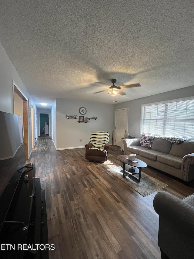 unfurnished living room featuring ceiling fan, dark wood-type flooring, and a textured ceiling