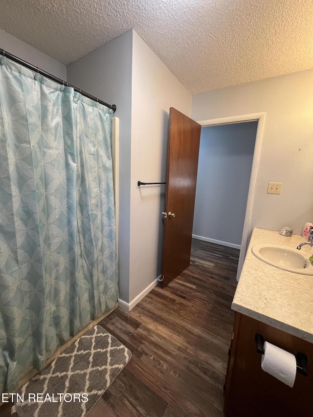 bathroom featuring vanity, wood-type flooring, and a textured ceiling