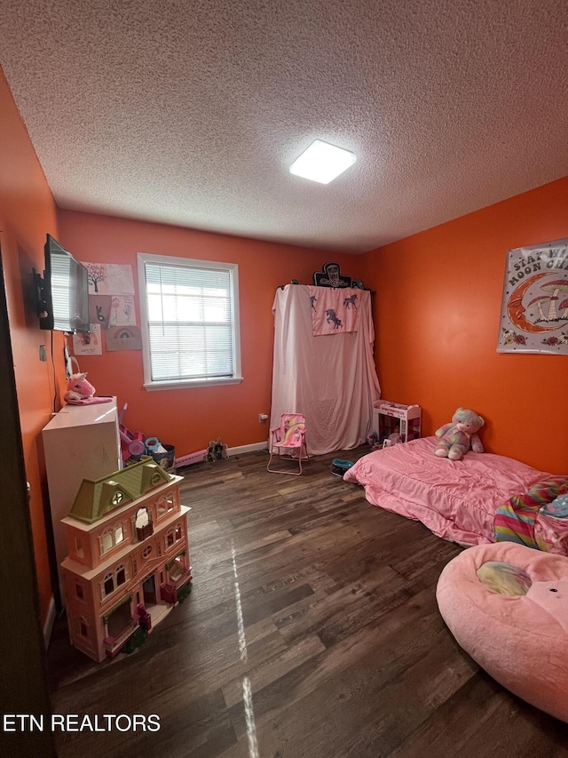 bedroom with a textured ceiling and dark hardwood / wood-style floors