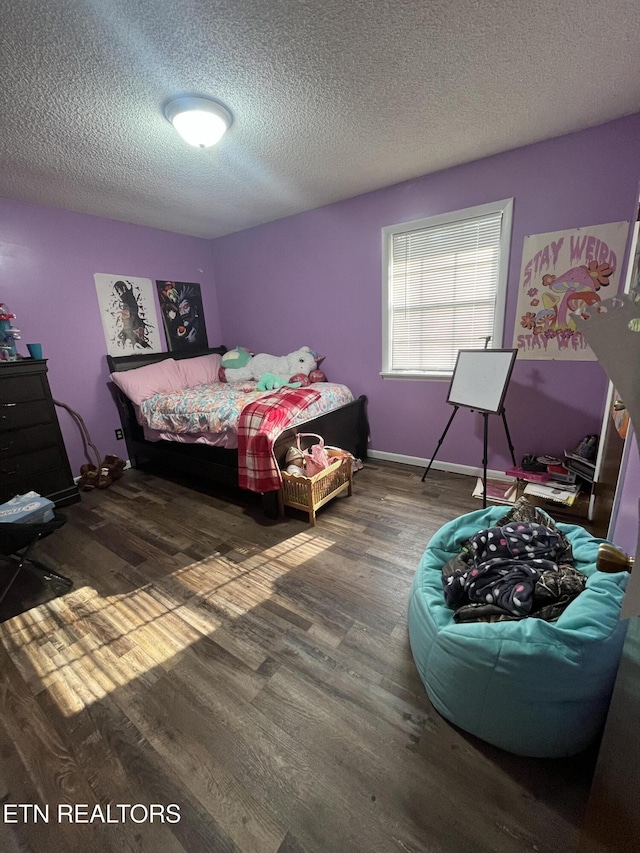 bedroom with a textured ceiling and dark hardwood / wood-style floors