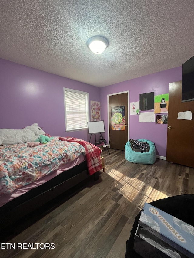 bedroom featuring hardwood / wood-style flooring and a textured ceiling