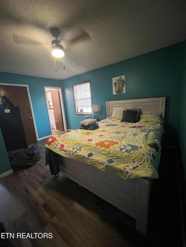 bedroom with ensuite bath, ceiling fan, a textured ceiling, and hardwood / wood-style flooring