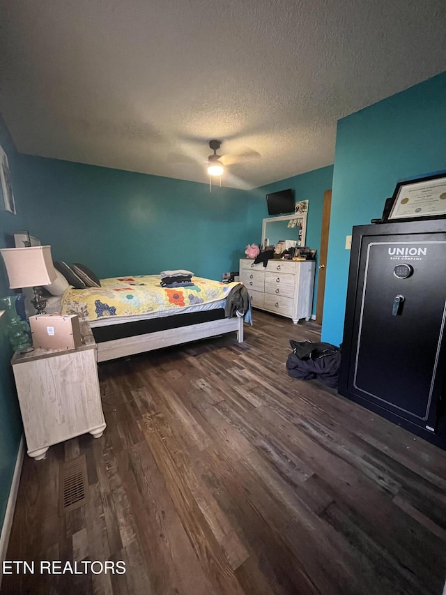 bedroom featuring a textured ceiling, ceiling fan, and dark wood-type flooring