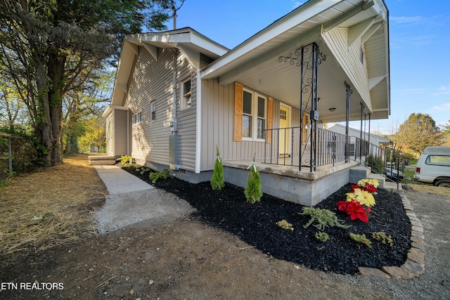 view of side of home featuring covered porch