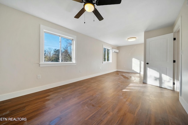 spare room featuring plenty of natural light, dark hardwood / wood-style flooring, and a wall mounted AC