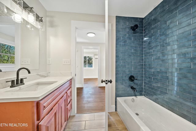 bathroom with vanity, tiled shower / bath combo, and hardwood / wood-style flooring