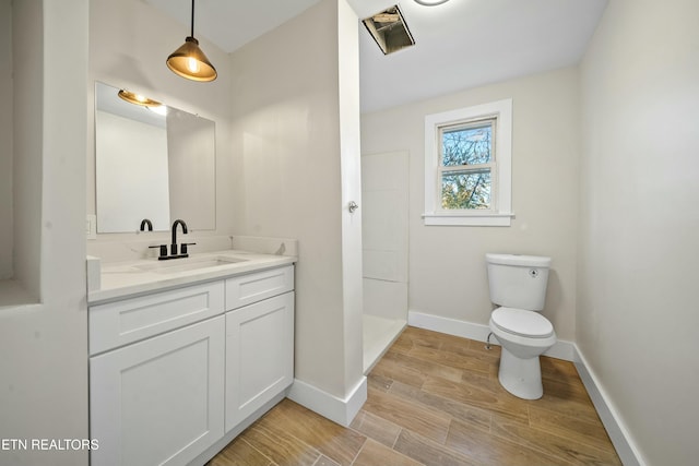 bathroom with vanity, hardwood / wood-style flooring, toilet, and walk in shower